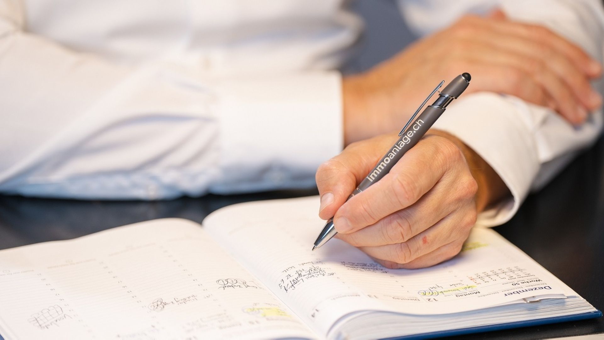 Speh+Partner Inhaber Michael Speh macht sich Notizen in einem Notizbuch